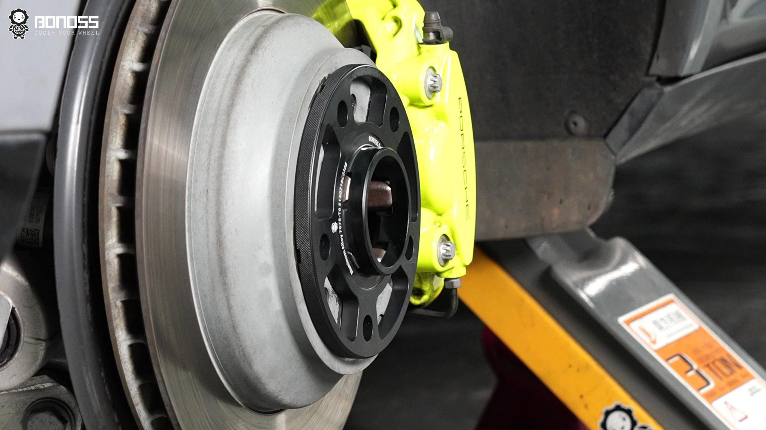 bonoss-10mm-spacer-seated-front-hub BONOSS 10mm Porsche-specific spacer seated on the Cayenne front hub, notches engaged with the five-finger step