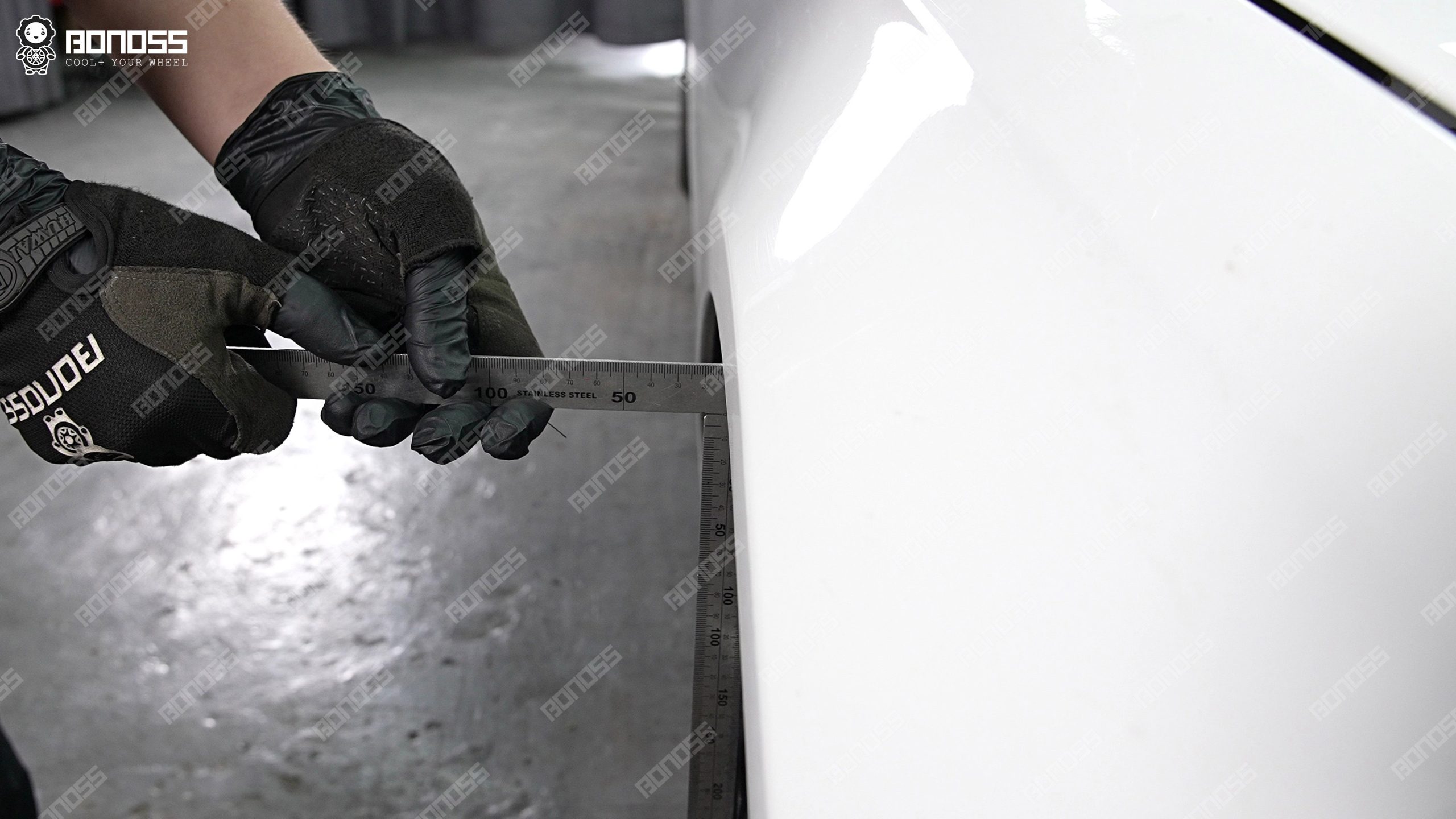 left-front-flush-measurement-2021-mercedes-benz-e-class-15mm-spacers Technician using a high-accuracy ruler to gauge front wheel inset on a 2021 Mercedes-Benz E-Class.