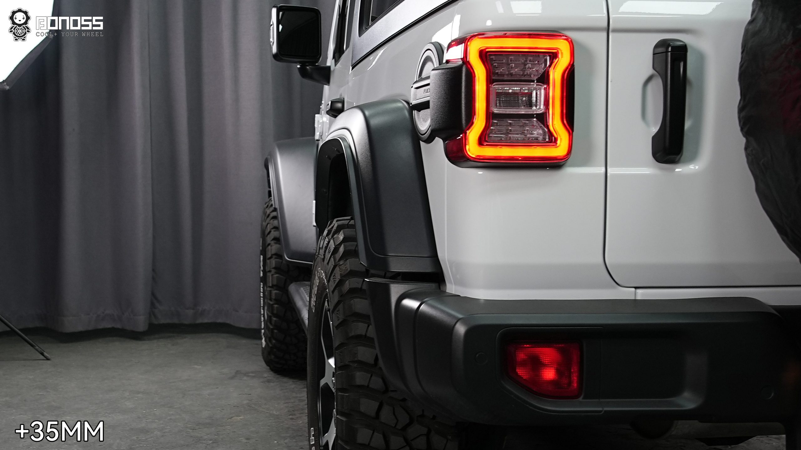 left-rear-wheel-flush-stance-after-35mm-spacer-wrangler Finished left rear corner of a 2021 Jeep Wrangler JL with the tire brought flush by a 35mm spacer.