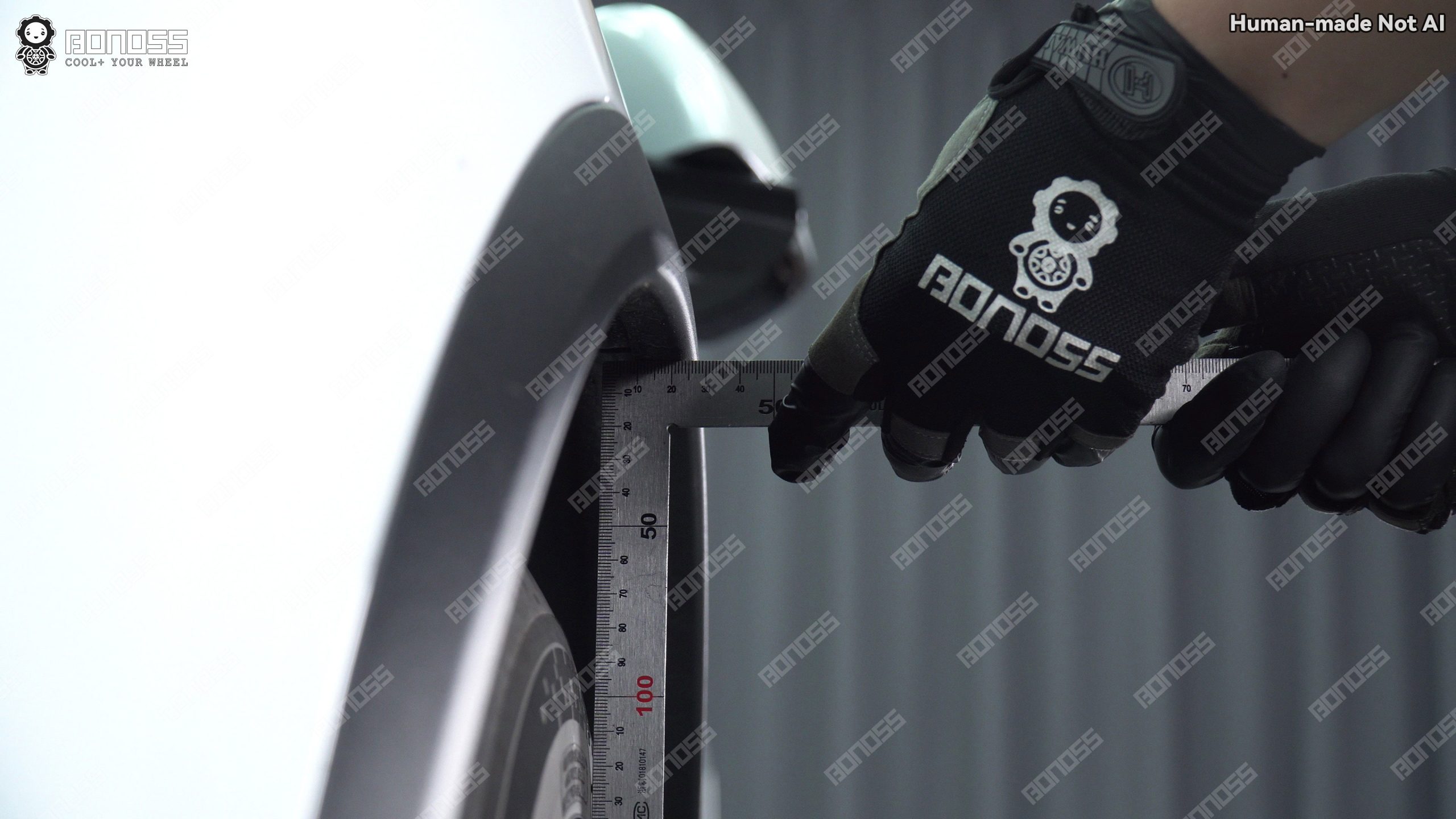 measuring-right-front-fender-gap-on-2023-tesla-model-x-with-ruler Technician checks right front fender clearance on a 2023 Tesla Model X before choosing spacer thickness.